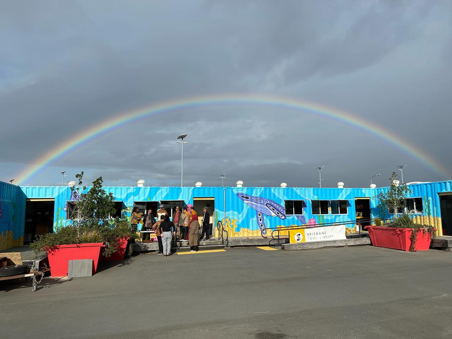 A shipping container with a rainbow over it